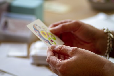 Close-up of hands holding a tarot card